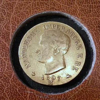 Monnaie d'or de 1807 posée dans l'alvéole d'un plateau de numismate.