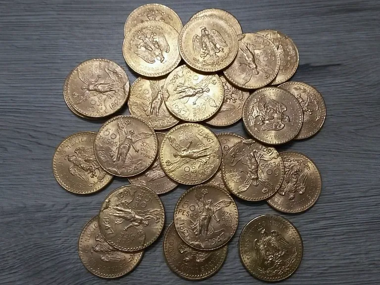 Pièces de 50 pesos mexicains en tas, avers et revers mêlés.